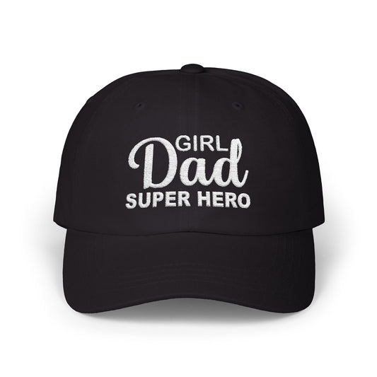 Woman wearing a black hat with white embroidered text that reads “Girl Dad Super Hero” while standing against a fence in casual attire