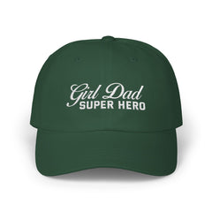 Woman wearing a black hat with mixed-script embroidered text reading “Girl Dad Super Hero” standing against a chain-link fence